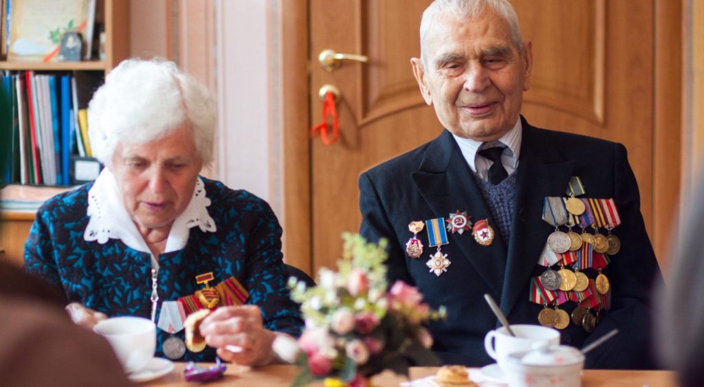 An elderly man and woman sitting at a table