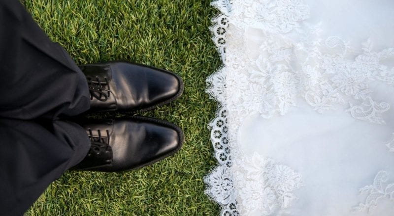 married couple standing on grass